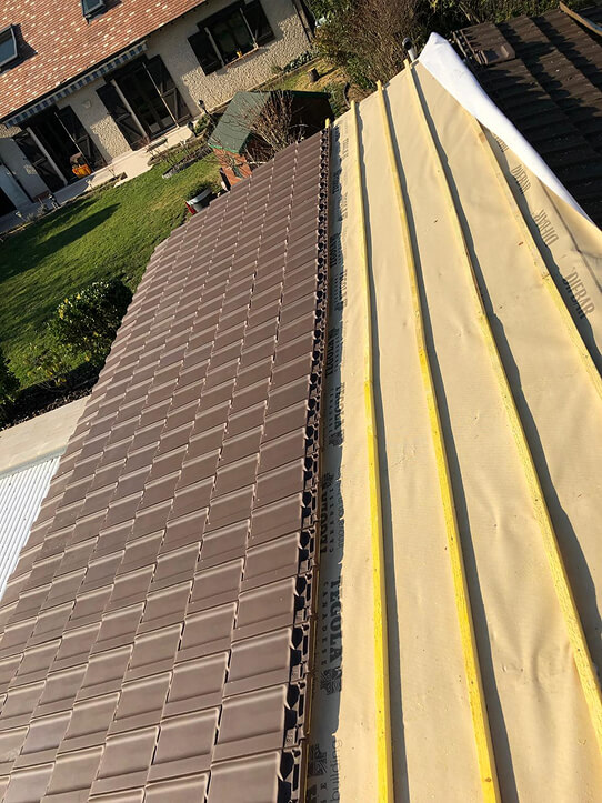 Travaux de couverture en cours Pose de tuiles neuves sur une charpente en Essonne